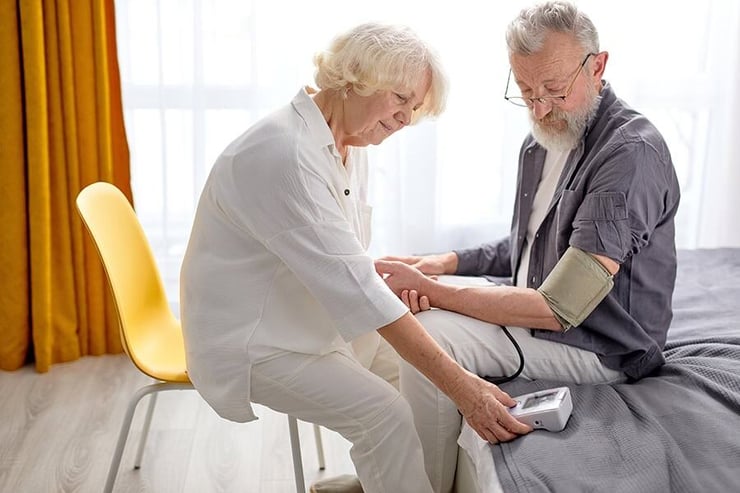 Woman reading the blood pressure reading for a man